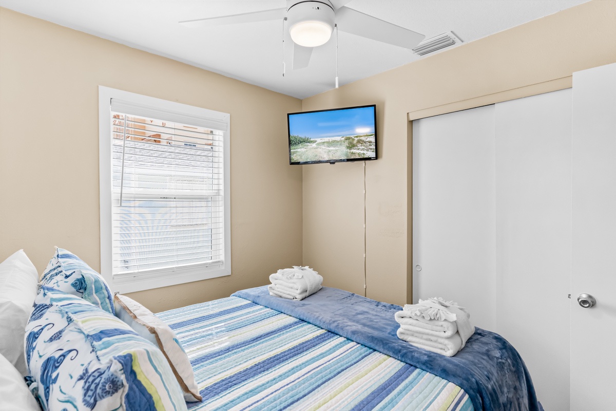 Your cozy bedroom features fresh towels, coastal-inspired linens, and entertainment at your fingertips.