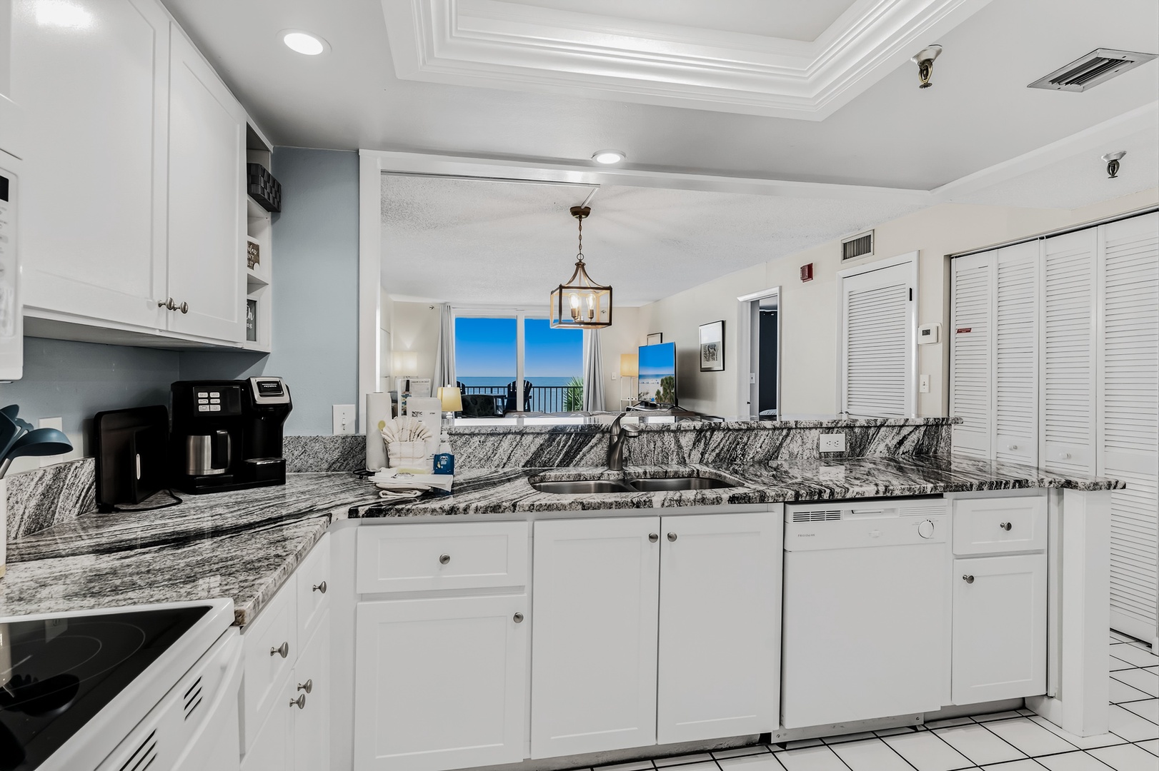 The bright open kitchen flows seamlessly into your living space, where ocean breezes and stunning blue skies await just beyond the windows. Sleek granite counters and modern appliances make meal prep a breeze.