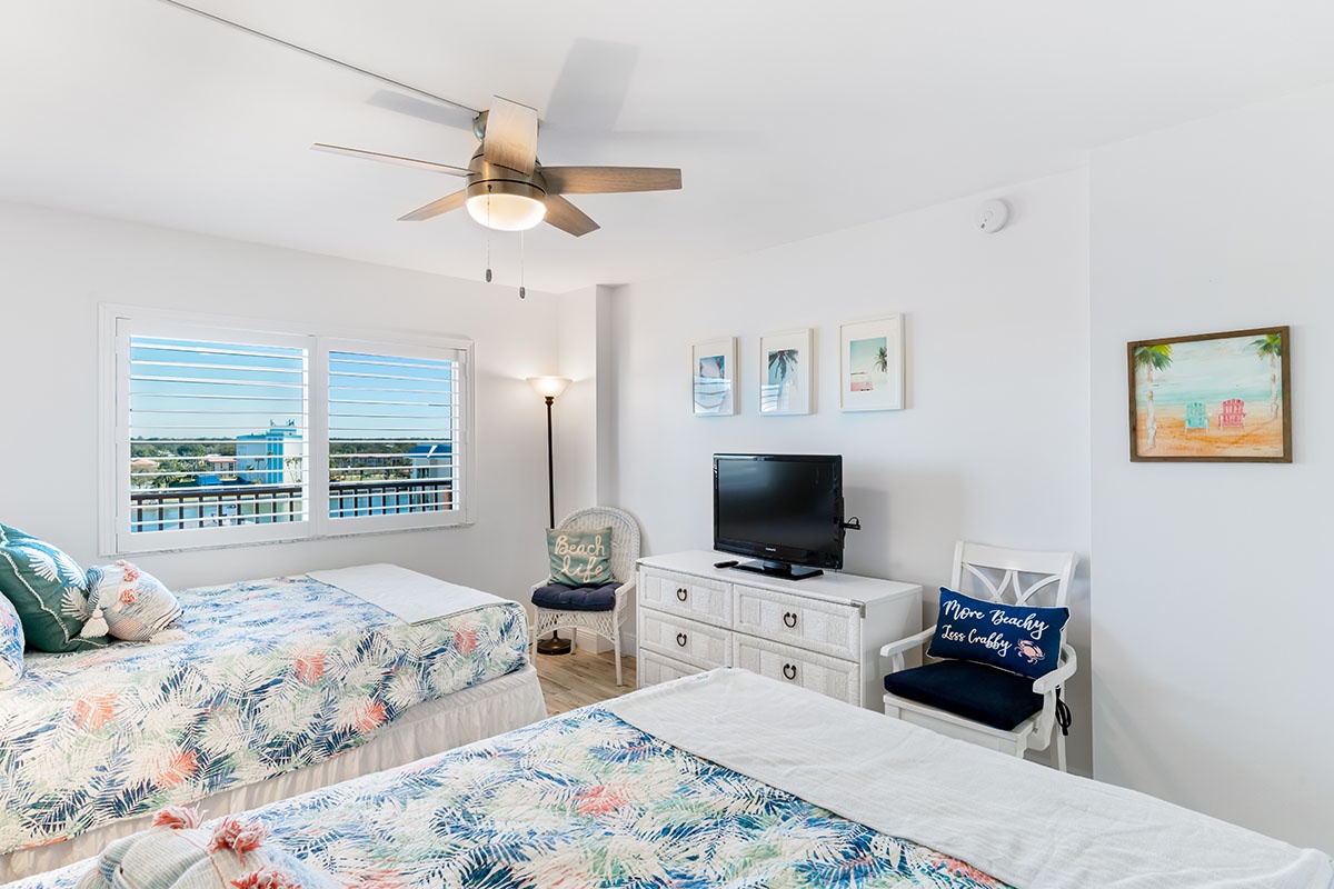 Unwind in your coastal retreat with twin beds dressed in tropical linens, ocean-themed artwork, and refreshing breezes from your ceiling fan.