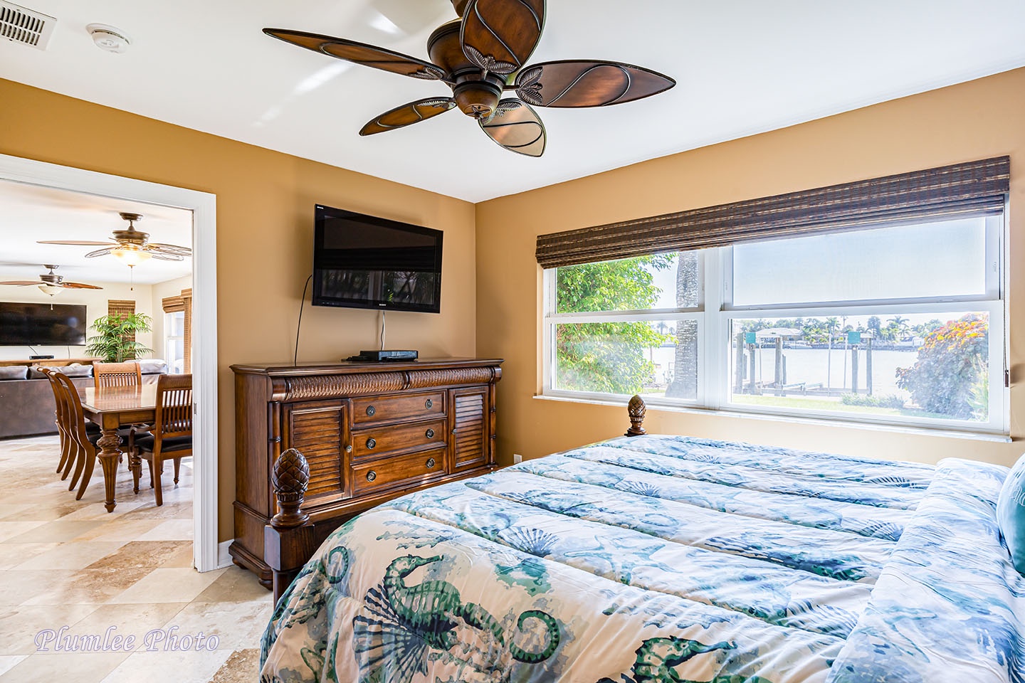 Master bedroom has mounted TV and ceiling fan for added comfort