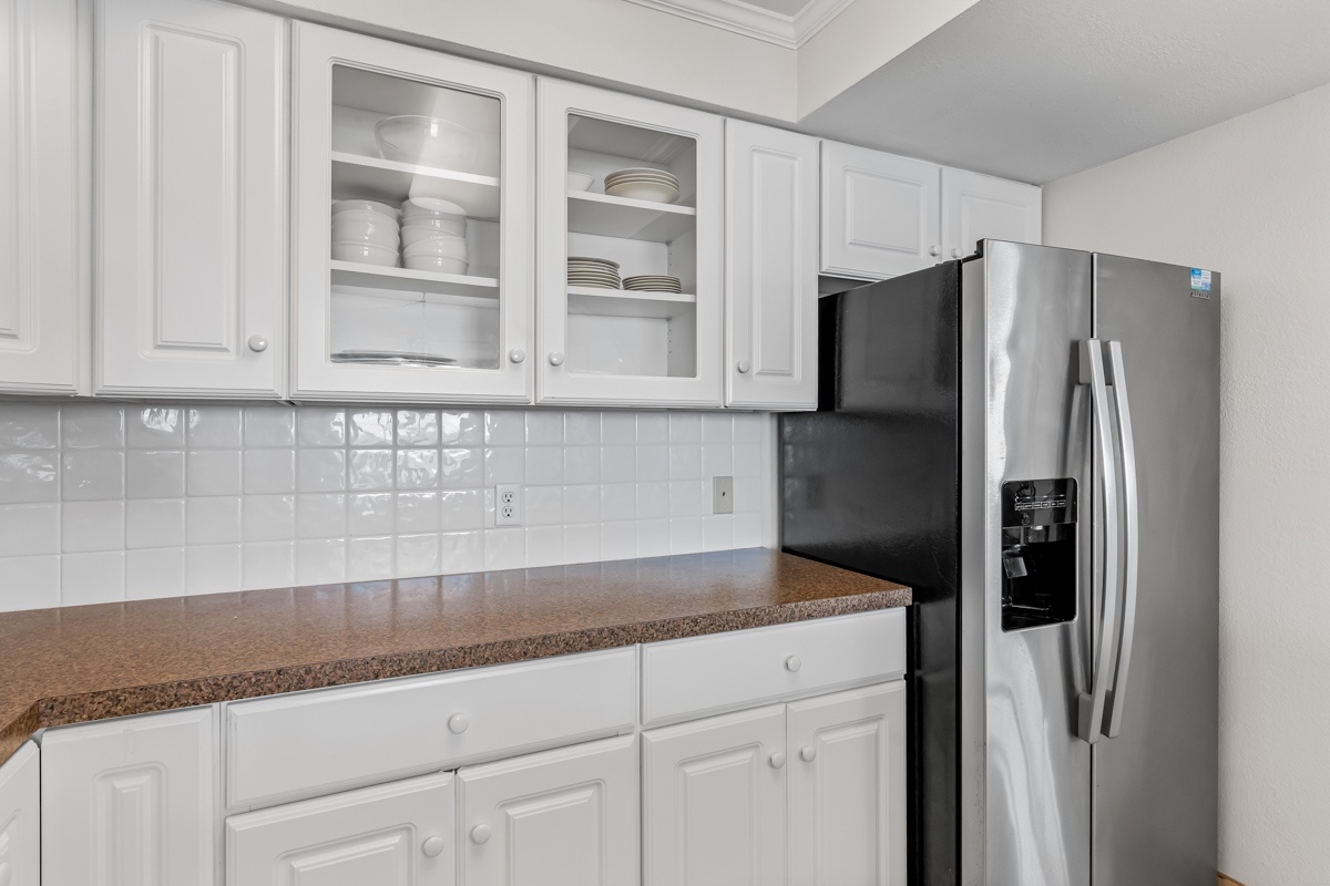 Your fully equipped kitchen features granite countertops, white subway tile backsplash, and stainless steel appliances for comfortable meal preparation.