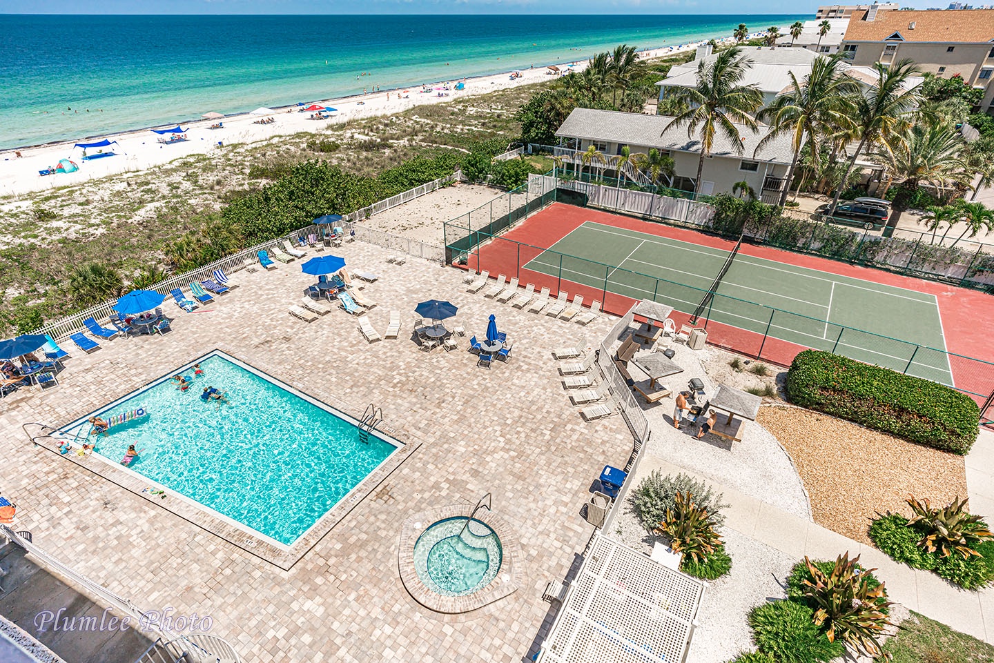 View of the pool deck and tennis court below