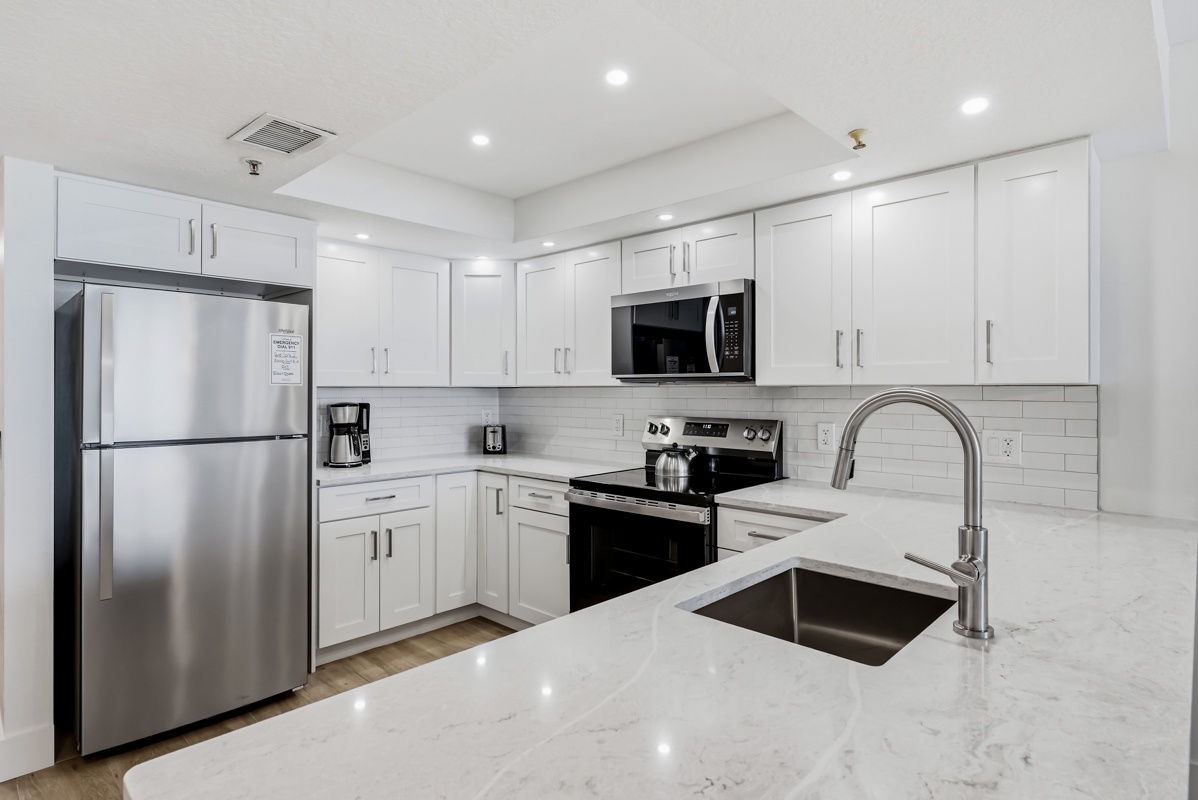 Your fully equipped kitchen features gleaming marble countertops, stainless steel appliances, and everything you need to create memorable meals.