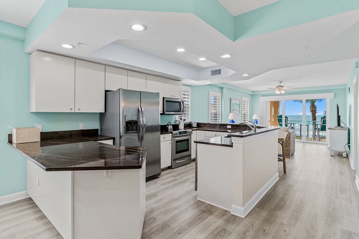 You'll love cooking in this bright, spacious kitchen with granite counters and ocean views from your balcony beyond.