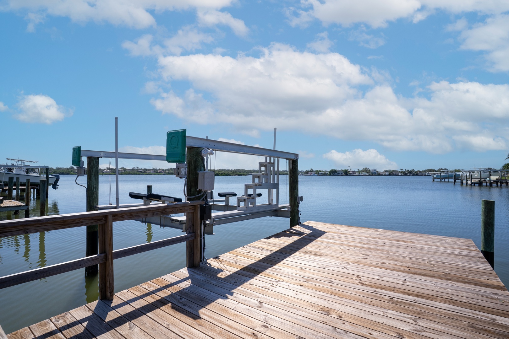 Private dock with boat lift extends into calm waters, offering direct waterfront access for boating adventures.