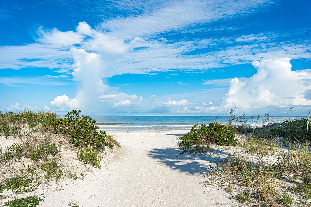 Pristine white sand beach with natural dunes and crystal-clear waters creates the perfect coastal escape nearby.