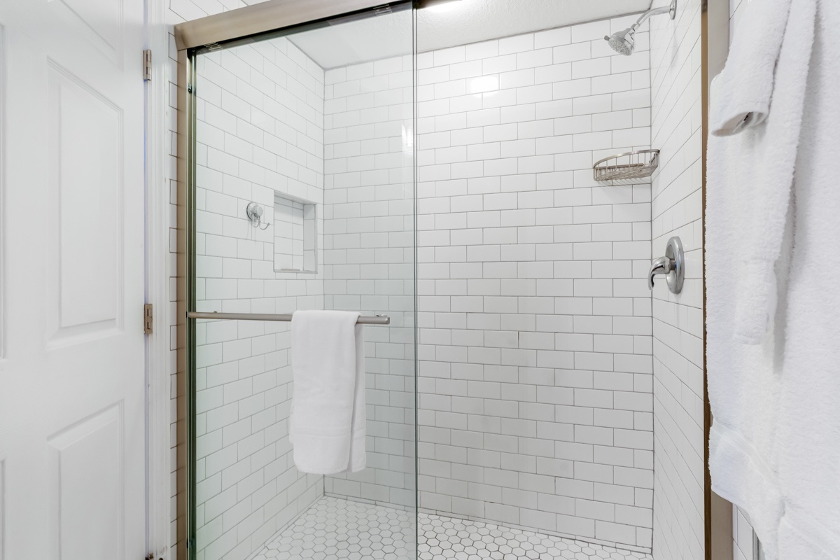 Indulge in your private spa-like shower with pristine subway tiles, elegant glass enclosure, and premium fixtures for ultimate relaxation.