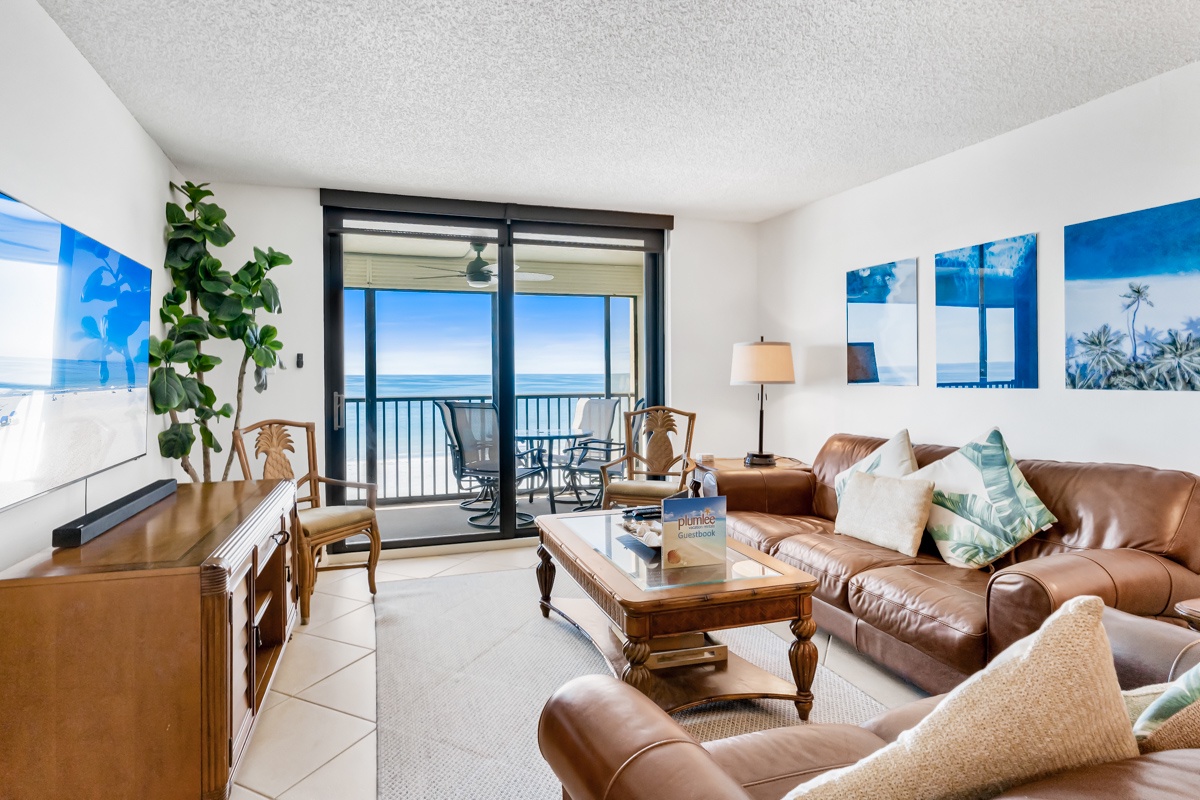 Sink into plush leather seating as your eyes wander from tropical touches to the stunning ocean view framing your private balcony—your perfect coastal retreat awaits.