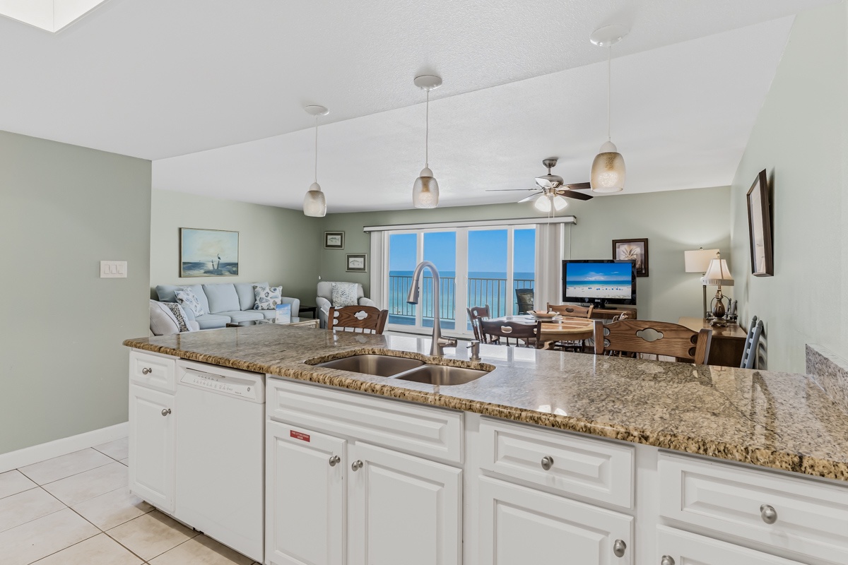 Prepare meals at the spacious granite island while enjoying breathtaking ocean views through floor-to-ceiling glass doors. The open layout seamlessly connects the kitchen, dining, and living areas—perfect for gathering with loved ones.