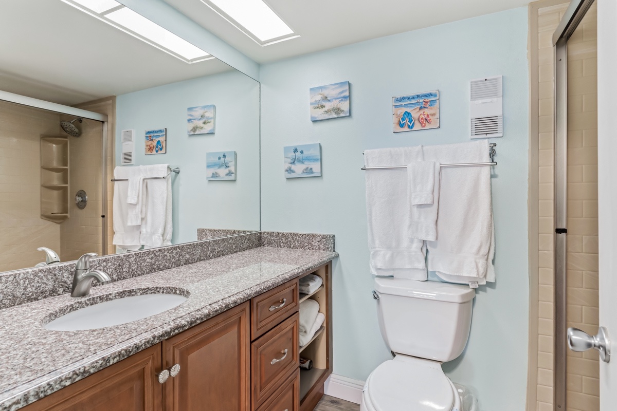 You'll find everything you need in this cheerful bathroom with its granite counters, soft towels, and coastal artwork that sets a relaxing vacation mood.
