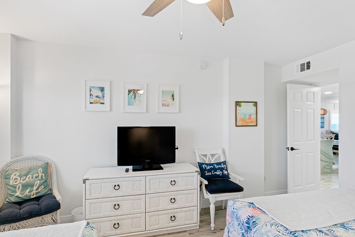 Unwind in your coastal-themed living space with beach artwork, comfy seating, and entertainment ready for your perfect vacation retreat.