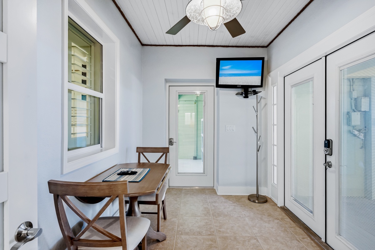 Your private work/dining awaits with a charming table, TV for entertainment, and peaceful views through large windows.