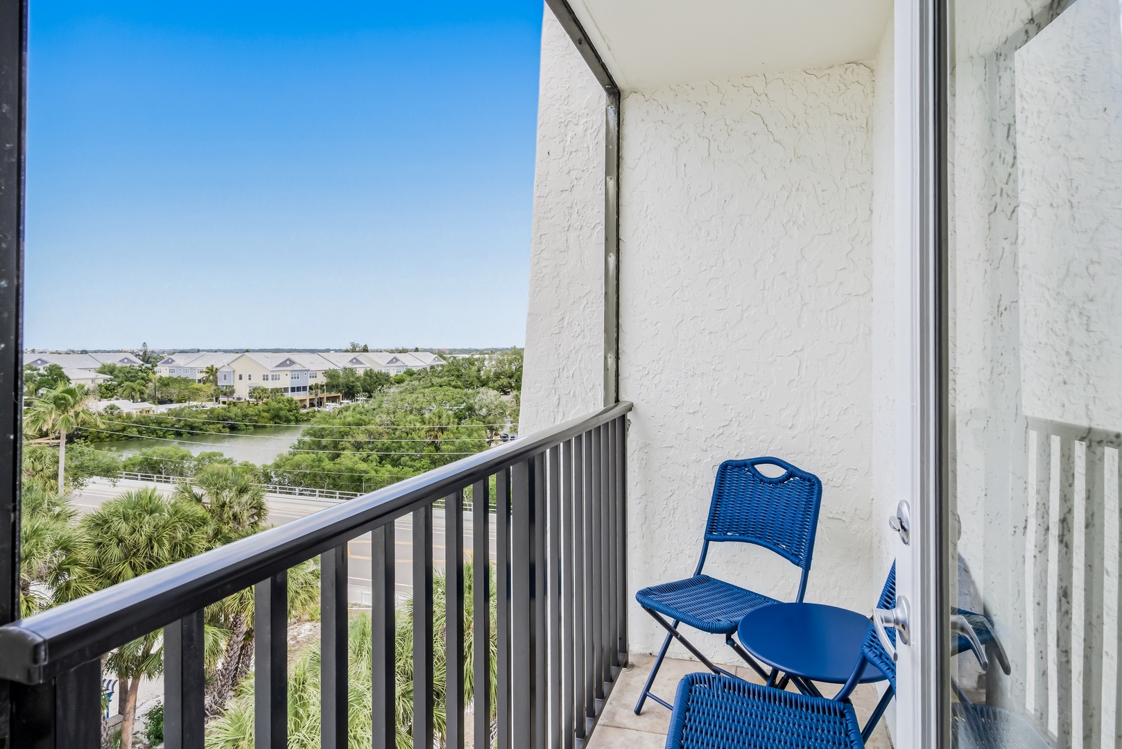 Step onto your private balcony and breathe in the peaceful water views, where palms sway and tranquil moments await beneath sunny blue skies.