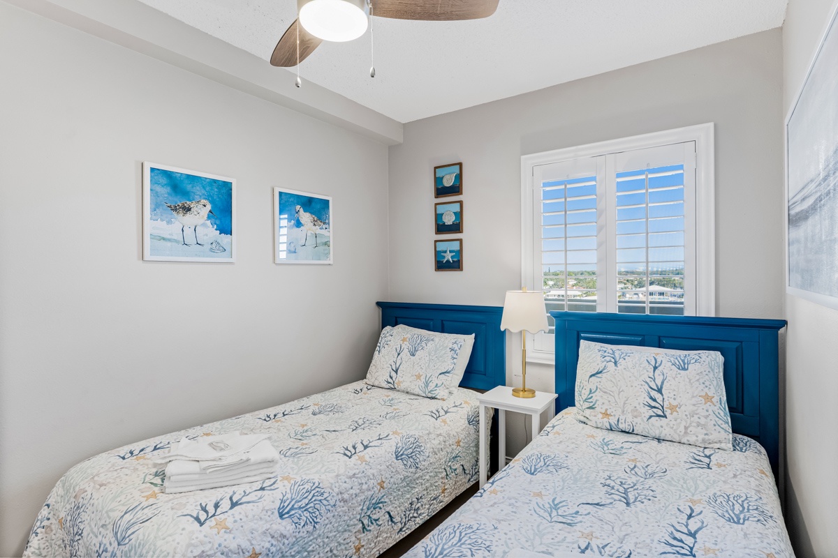 Drift into peaceful sleep in your bright twin bedroom, where coastal-themed bedding and charming artwork create a serene seaside retreat.
