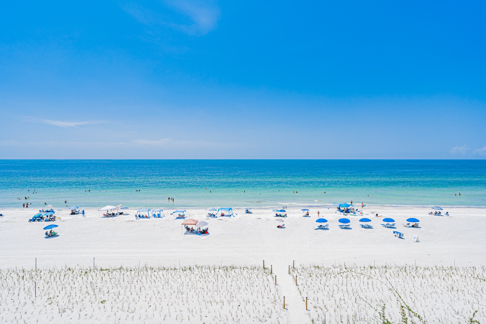 Pristine white-sand beach meets turquoise waters under endless blue skies, creating an idyllic coastal escape near the property.