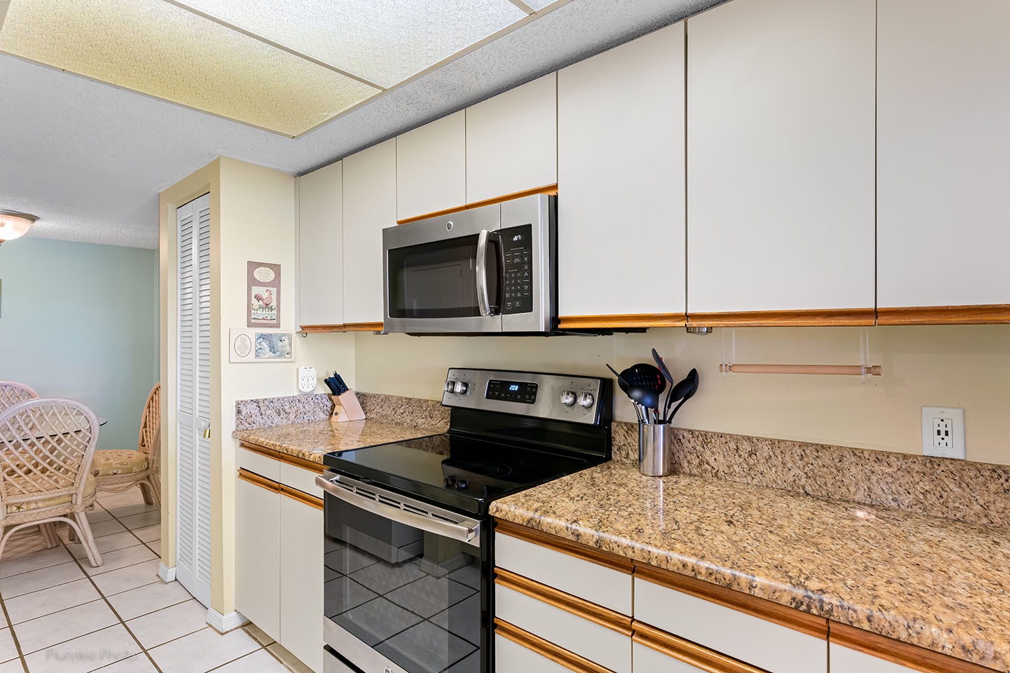 Kitchen has granite counters and glass stove top