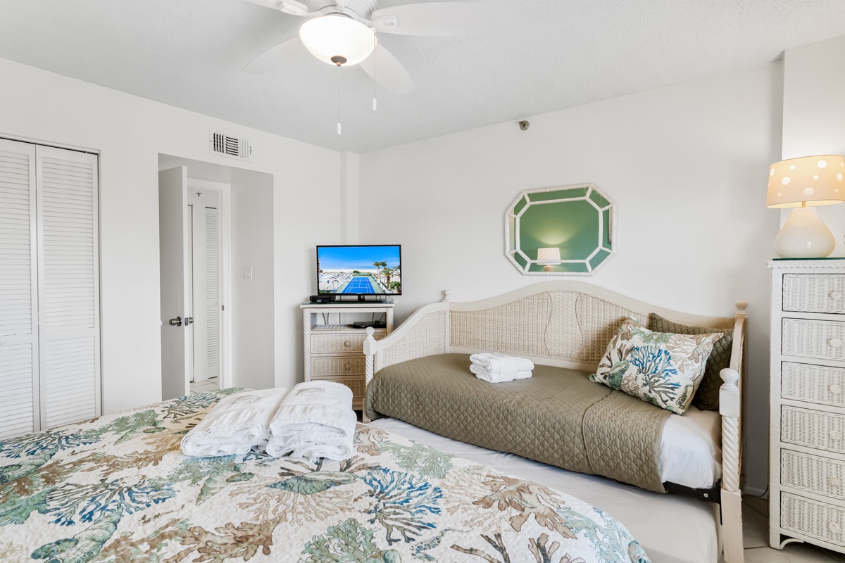 Your coastal-inspired bedroom features a comfortable bed and daybed, perfect for relaxing while watching TV after beach days.