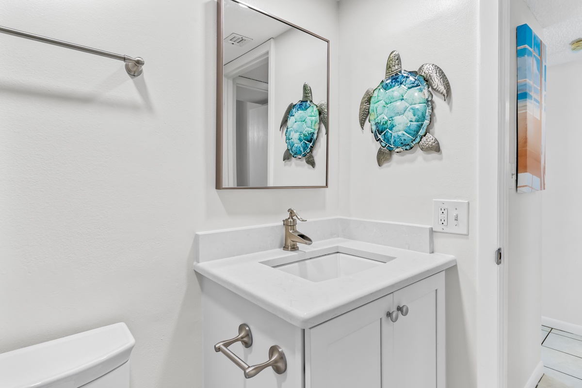 Step into your beautifully appointed bathroom with charming sea turtle art and modern fixtures for a refreshing start to your day.
