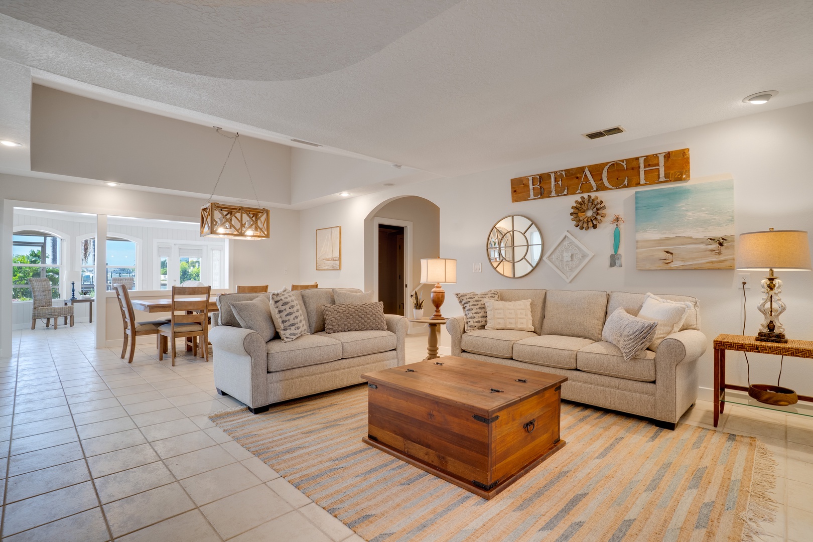 Relax in your spacious living room with coastal charm, featuring plush sofas and beach-themed decor.