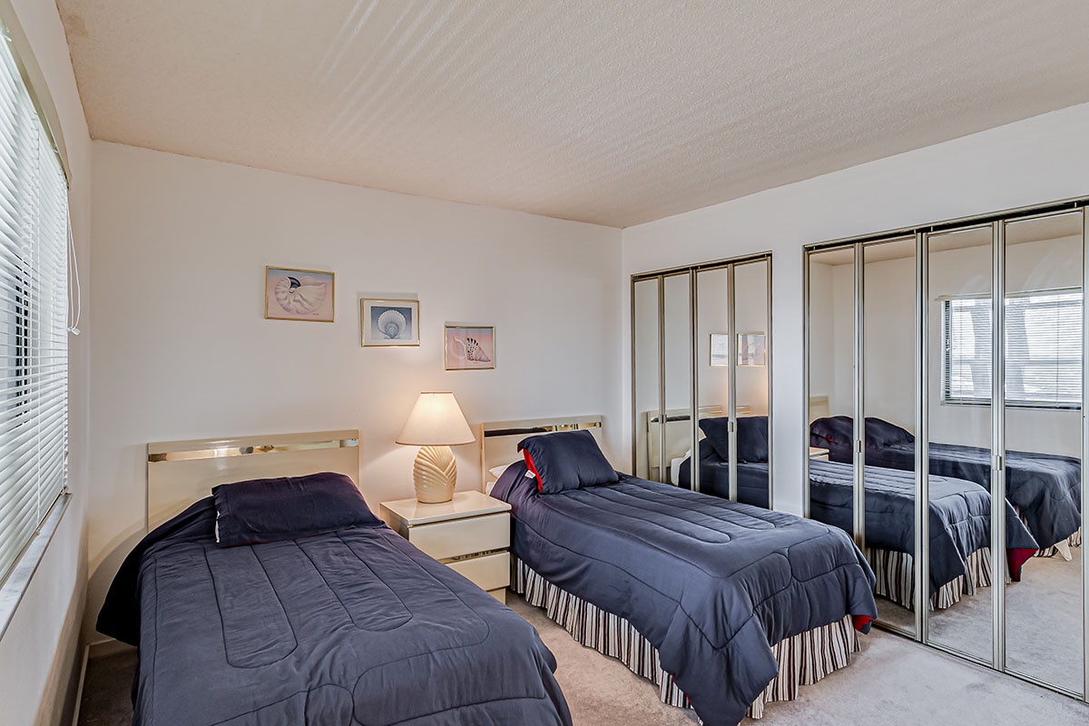 Rest peacefully in this bright twin bedroom with comfortable beds, ample wardrobe space, and natural light streaming through your window.