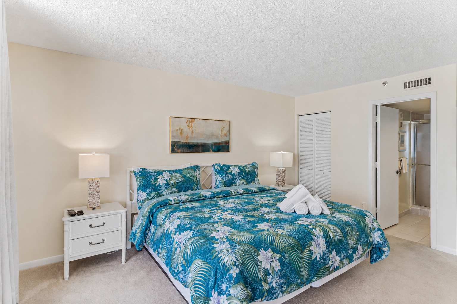 Sink into tropical luxury in your serene bedroom with fresh linens, soft lighting, and an en-suite bathroom just steps away from restful sleep.