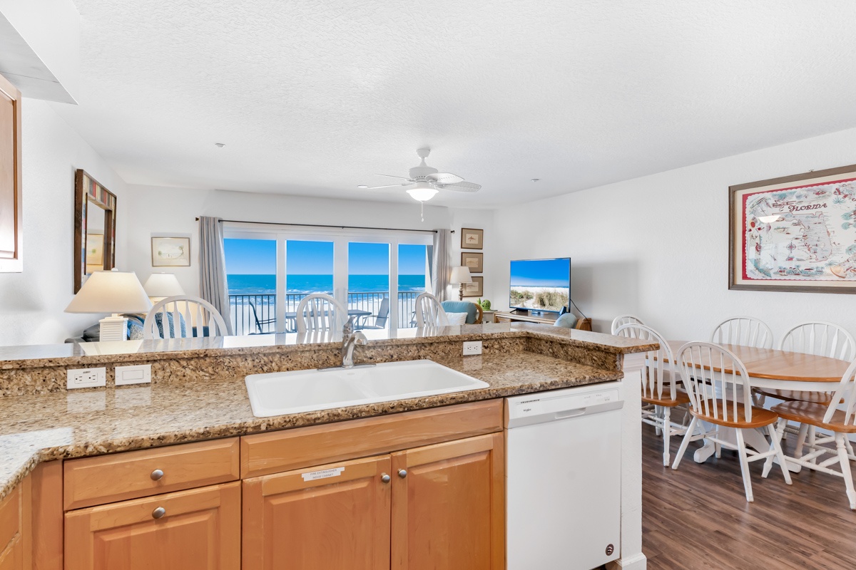 Your oceanfront kitchen flows into a bright dining space where every meal comes with stunning sea views through floor-to-ceiling windows.