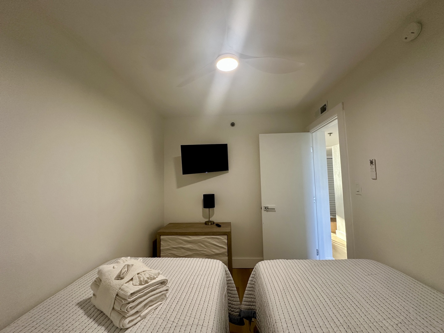 Your cozy bedroom features fresh linens, wall-mounted TV for relaxation, and clean modern design for a restful stay.