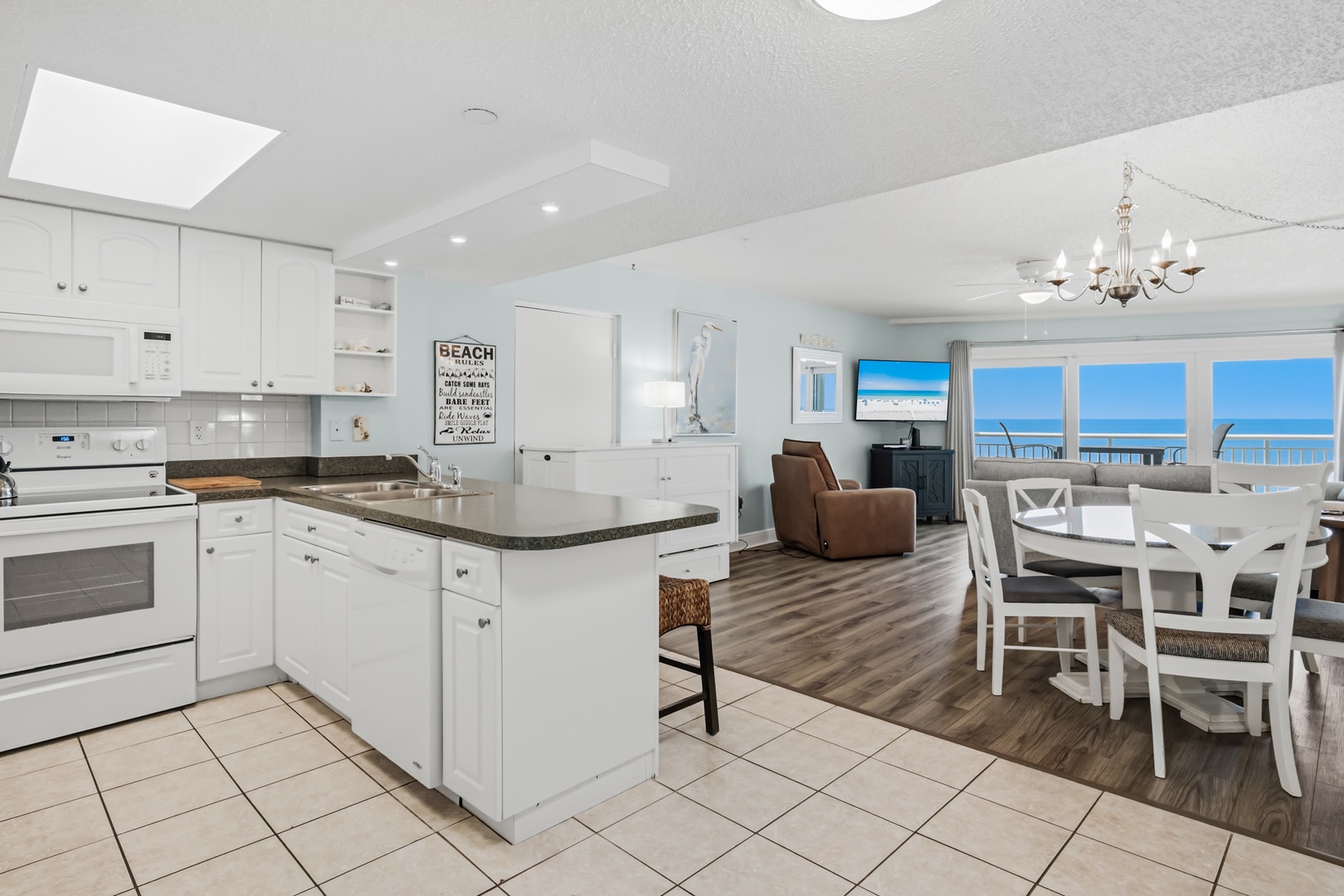 Step into your bright, open-concept retreat where the kitchen flows seamlessly into the living and dining areas. You'll love preparing meals while soaking in stunning ocean views through expansive windows that flood the space with natural light.