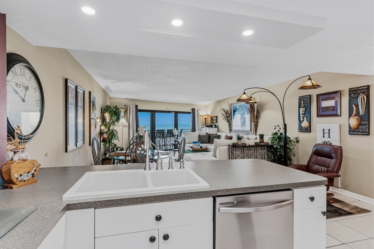 A fully-equipped kitchen flows into an open living area where you'll enjoy ocean views. Granite countertops, modern appliances, and stylish coastal décor create a comfortable space for cooking and gathering.