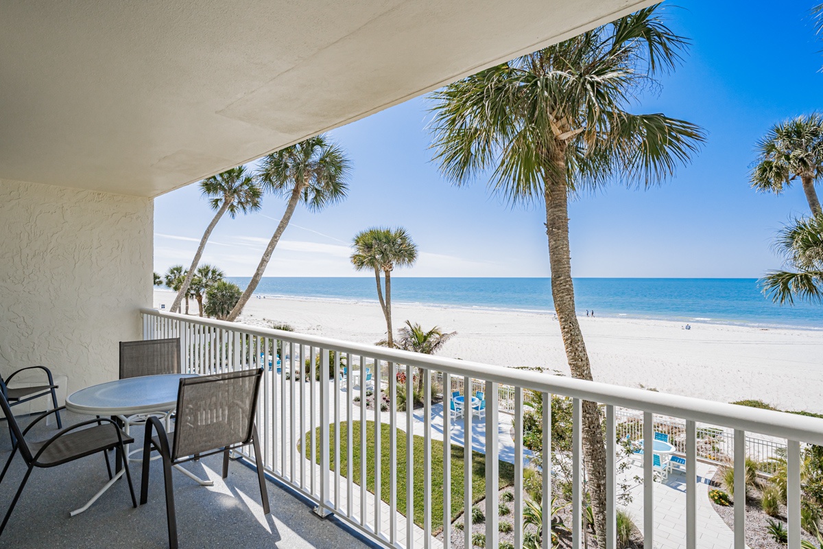 Sip your morning coffee from this private balcony overlooking swaying palms and sparkling turquoise waters. Your own coastal sanctuary awaits—just steps from the sand.