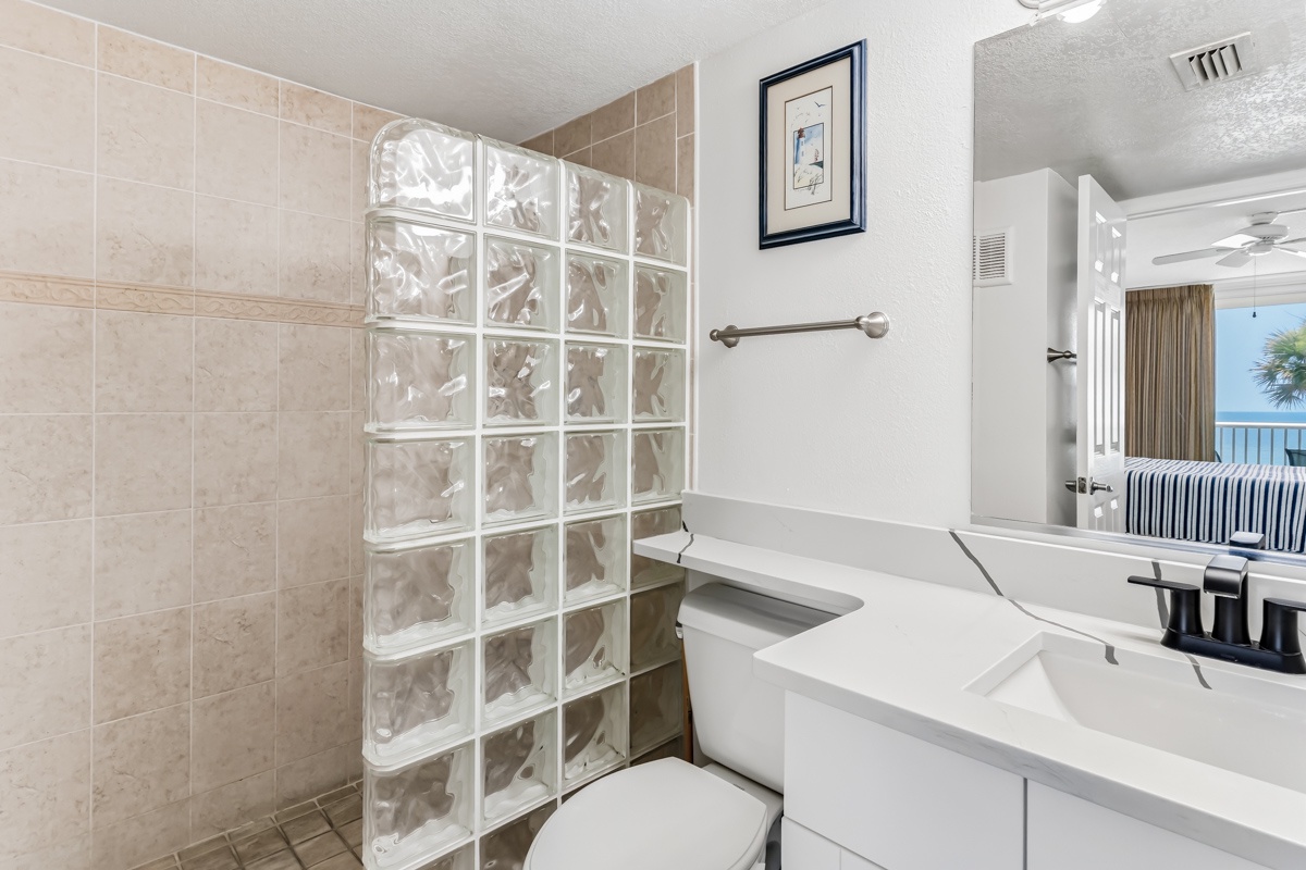 Your private bathroom features a walk-in glass block shower, modern fixtures, and a genuine ocean view from beyond—so you can refresh in style and step straight into paradise.