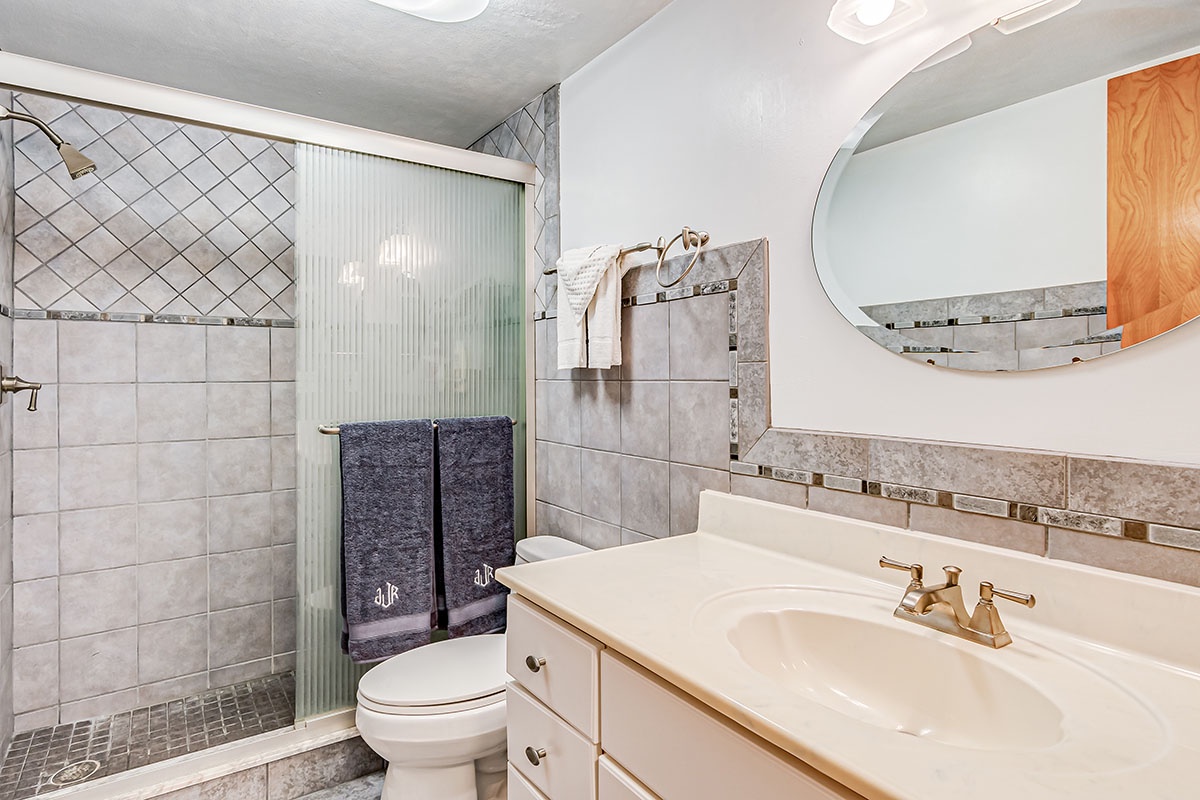 Your private bathroom features a spacious walk-in shower with elegant tile work and a comfortable vanity for your daily routine.