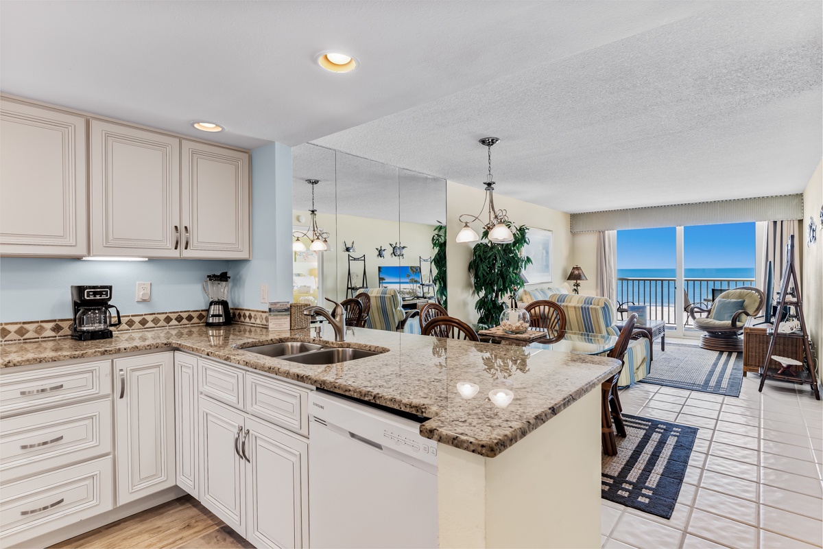 Spacious coastal retreat with open kitchen, gleaming granite counters, and private balcony overlooking the ocean—the perfect beachfront escape.