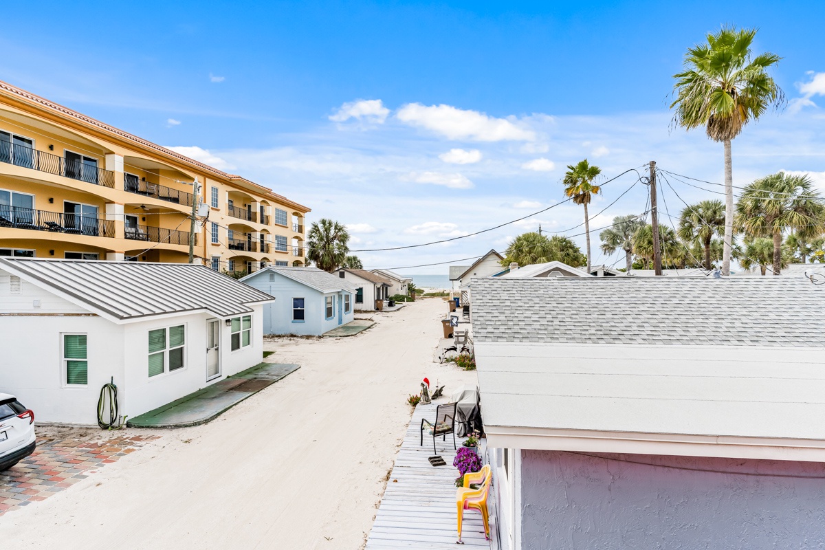 Lou's Starfish Haven is located just steps from the beach with other beach cottages surrounded by swaying palm trees under bright blue skies.