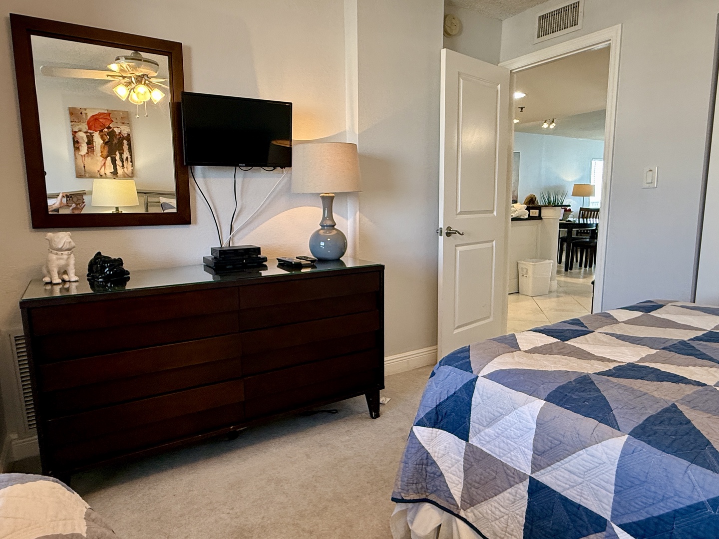 Relax in your stylish bedroom featuring a comfortable bed, modern dresser with flatscreen TV, and thoughtful touches throughout.