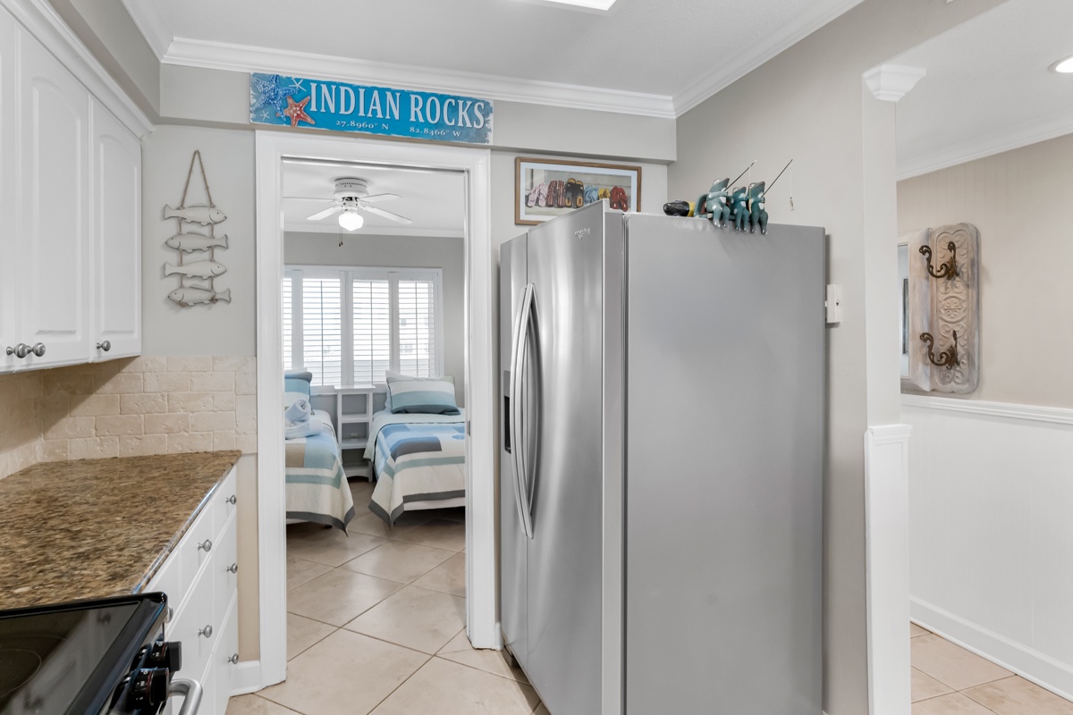 Your spacious kitchen flows seamlessly into the bedroom, with stainless appliances and charming beach decor creating a coastal retreat atmosphere.