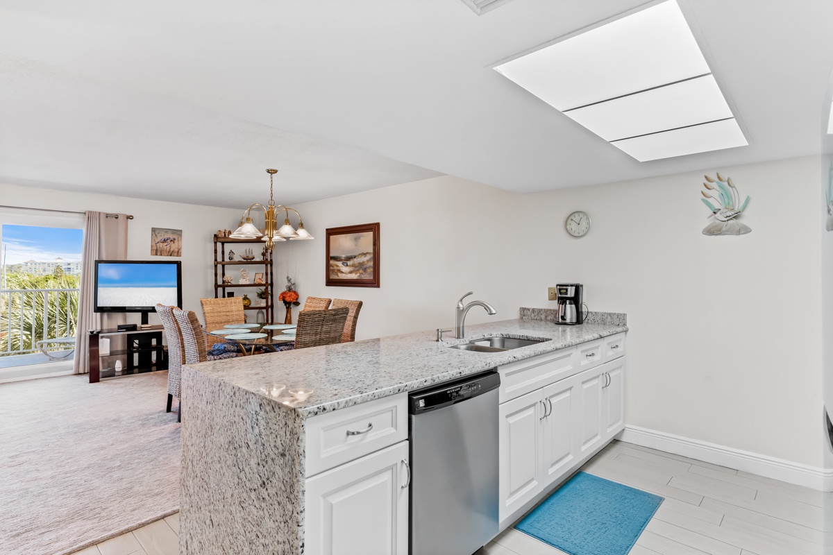 Your spacious kitchen flows seamlessly into the dining area, where granite counters and stainless appliances make cooking effortless while you enjoy natural light streaming through skylights.