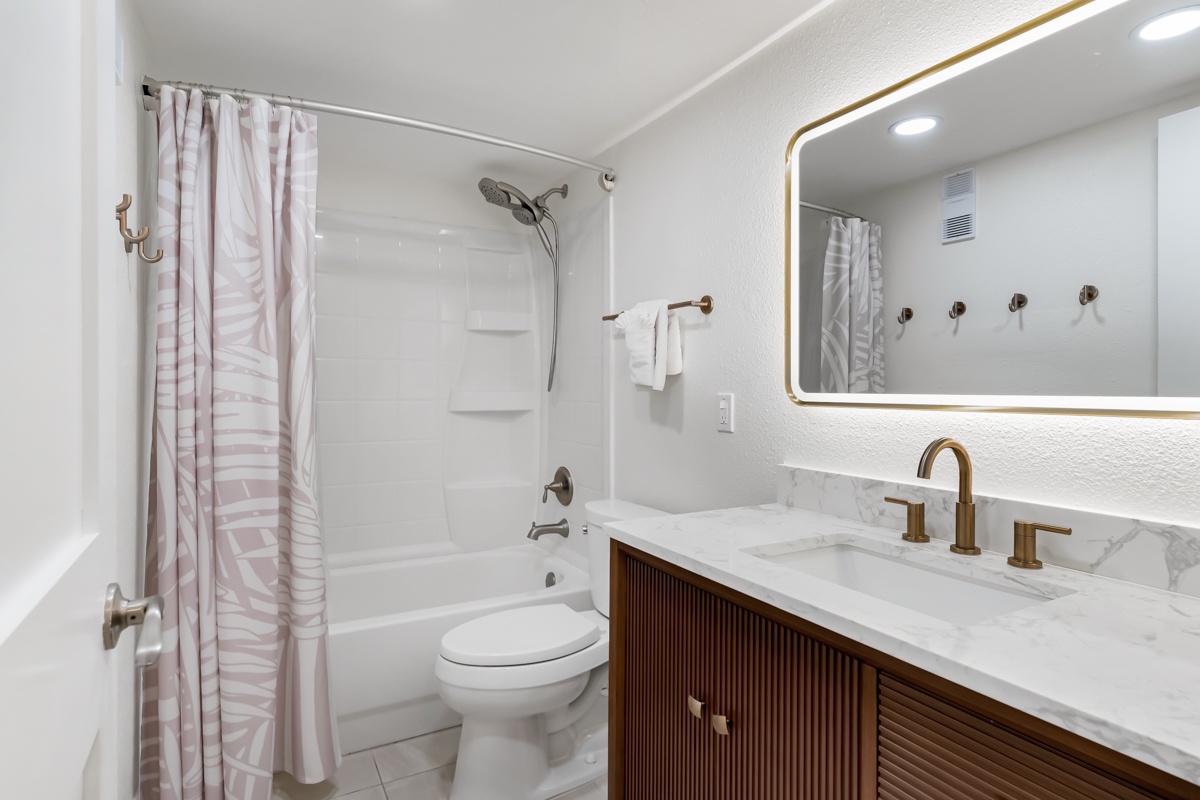 Step into your beautifully appointed bathroom, where modern fixtures meet classic comfort. Refresh in the tub-shower combo with soft towels waiting, and enjoy the elegant marble vanity and warm brass accents throughout.