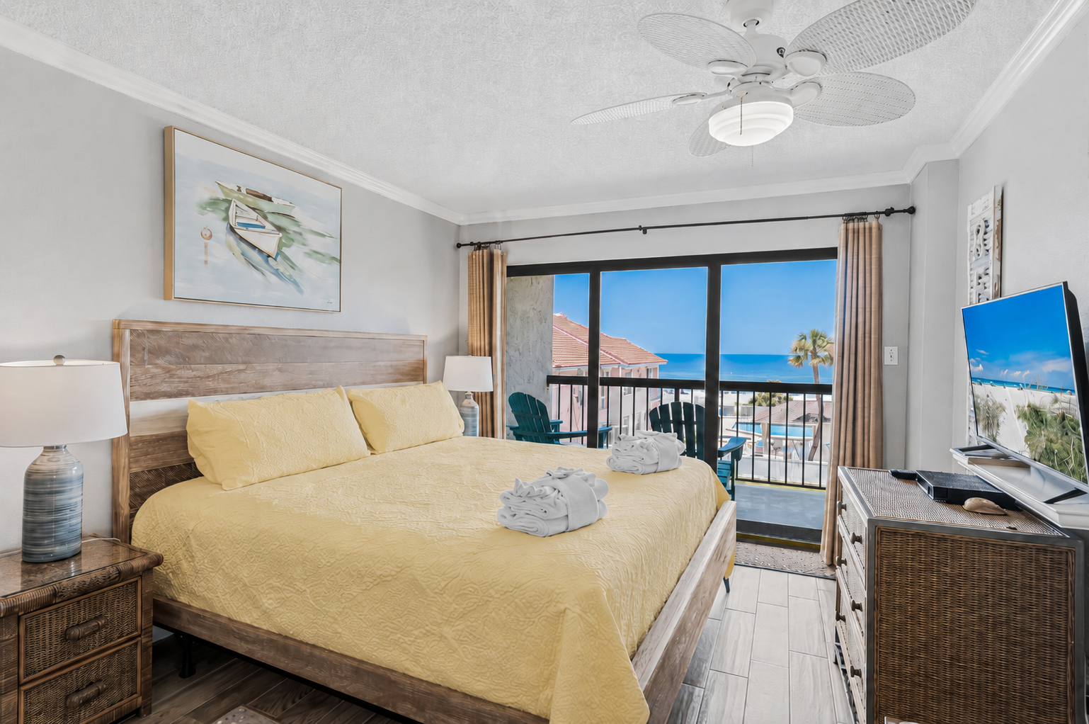 Wake up to stunning ocean views framing your private balcony. Crisp linens, coastal decor, and a gentle ceiling fan create your perfect beachside retreat.