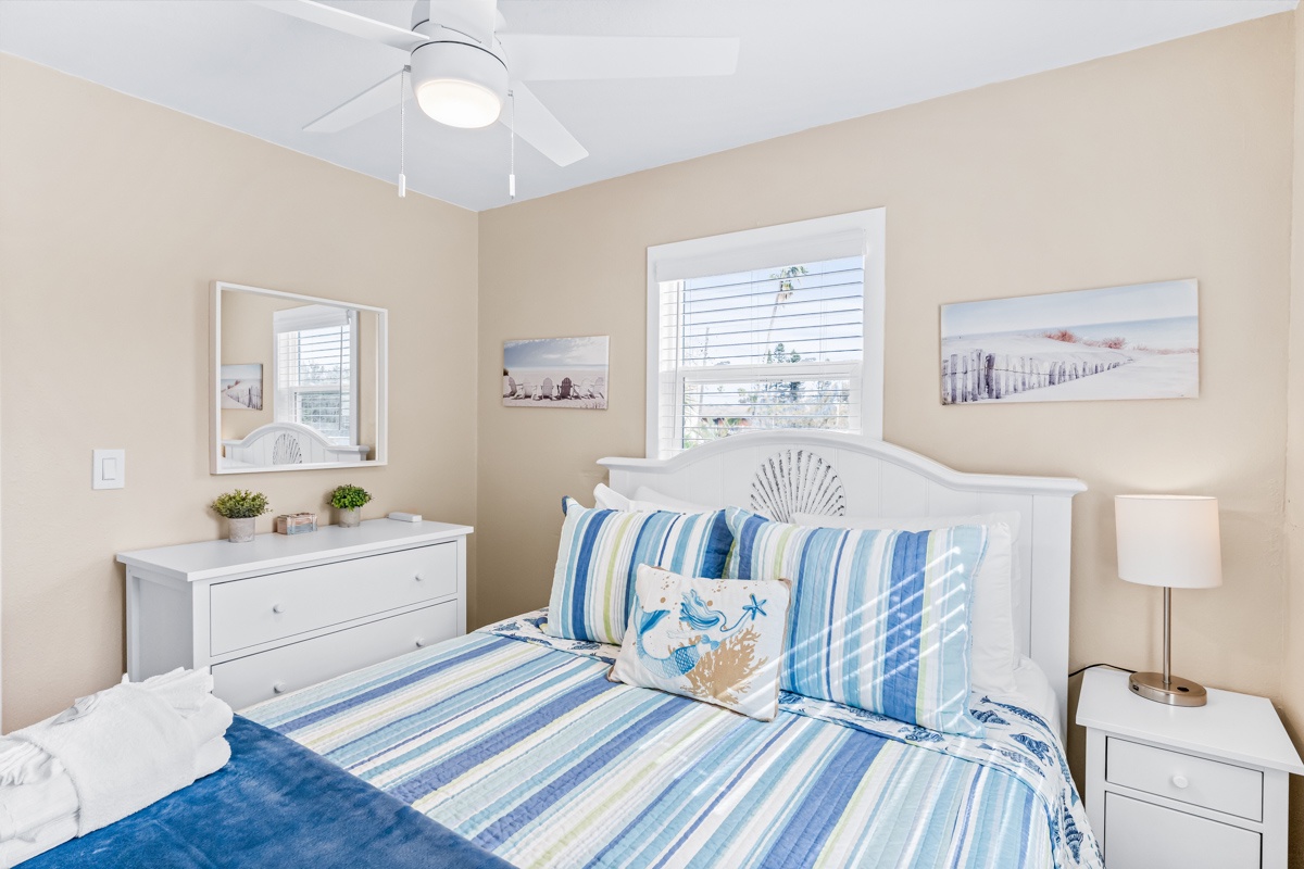Drift off in your coastal-themed bedroom where ocean breezes from the ceiling fan and beach artwork create your perfect seaside retreat.