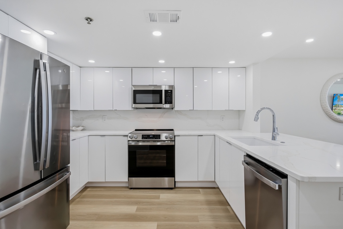 Your modern kitchen awaits with sleek white cabinets, stainless steel appliances, and pristine quartz countertops.