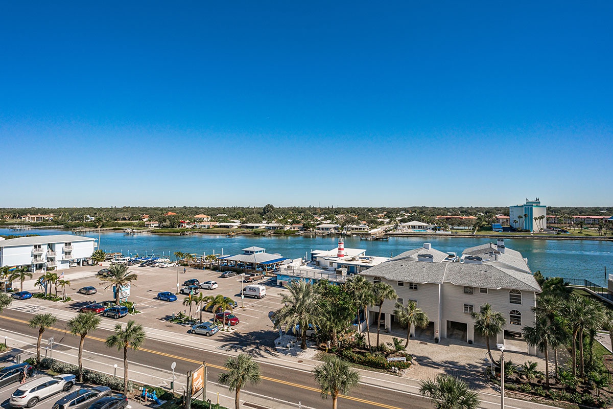 Aerial view shows the waterfront area with marina, restaurants, and coastal community surrounding the property location.