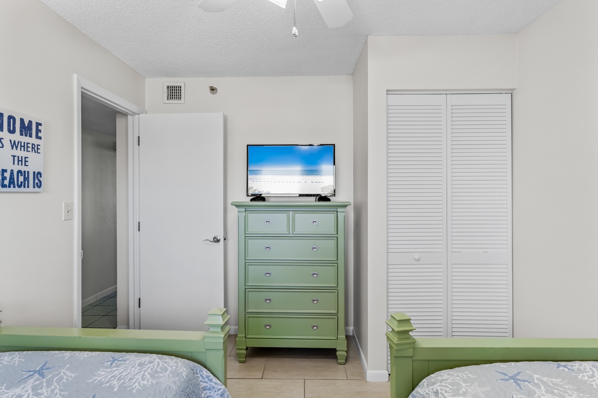 Unwind in your coastal-themed bedroom with twin beds, flat-screen TV, and charming mint furniture that perfectly captures beachy vibes.