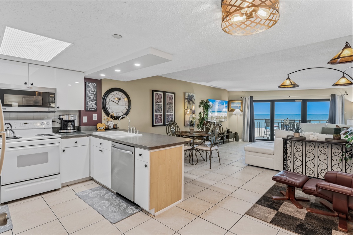 Picture yourself preparing meals in your fully-equipped kitchen while enjoying stunning ocean views through the large sliding doors. This open-concept space seamlessly connects cooking, dining, and lounging areas for effortless beachside living.
