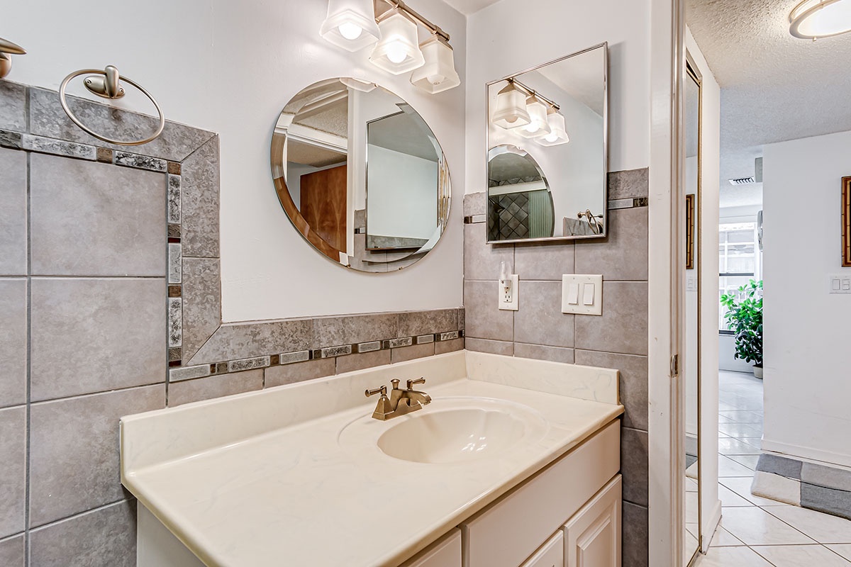 Your elegant bathroom features gold fixtures and stylish lighting, creating a sophisticated space for your morning routine.