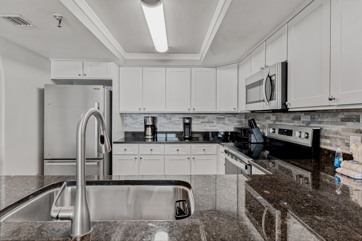 Cook your favorite meals in this bright, fully equipped kitchen featuring sleek granite countertops, stainless steel appliances, and ample cabinet space for all your culinary needs.
