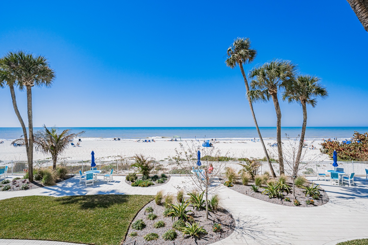 Beachfront paradise with swaying palms and pristine white sand stretching endlessly before turquoise waters.