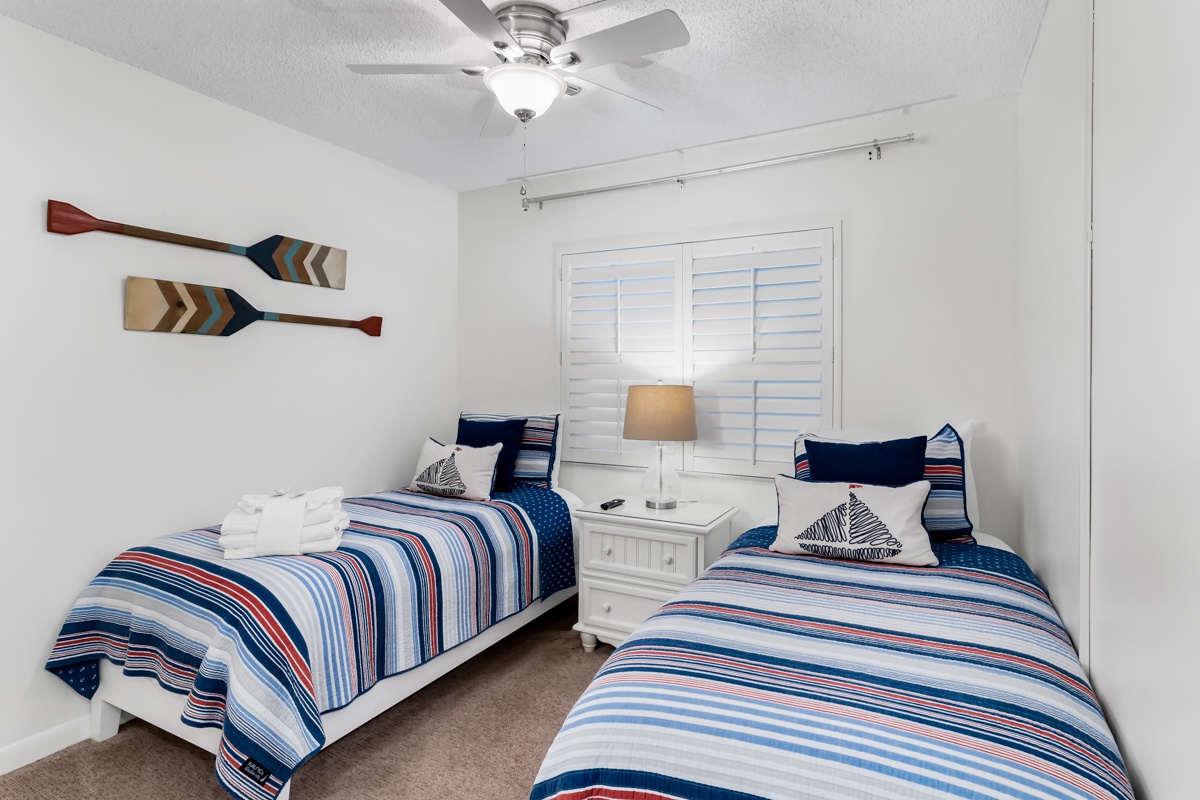 Rest comfortably in this nautical-themed twin bedroom with ceiling fan keeping you cool. Playful oar decor and crisp linens create a coastal retreat perfect for your group or family.