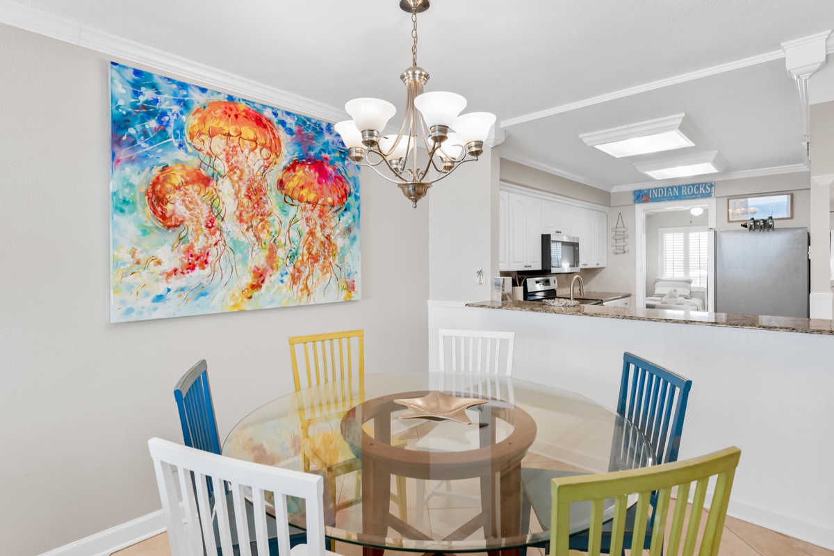 Gather around your dining table where vibrant ocean art and colorful chairs create the perfect backdrop for memorable meals together.