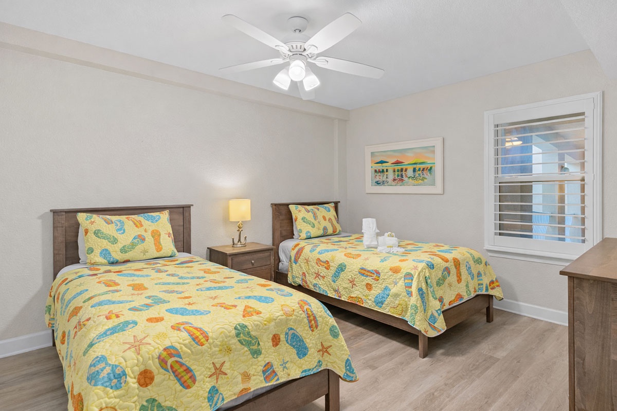 3rd bedroom with 2 twin beds, ceiling fan and smart TV